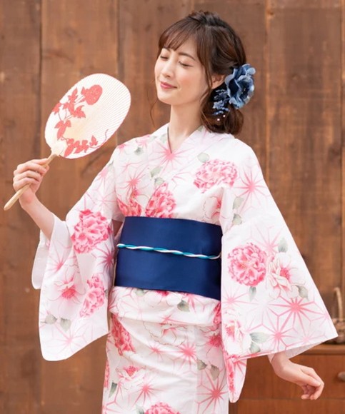 Một người mặc yukata cotton màu sáng cầm quạt giấy trong lễ hội mùa hè
