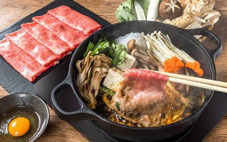 Nồi lẩu sukiyaki nóng với thịt bò thái mỏng và rau