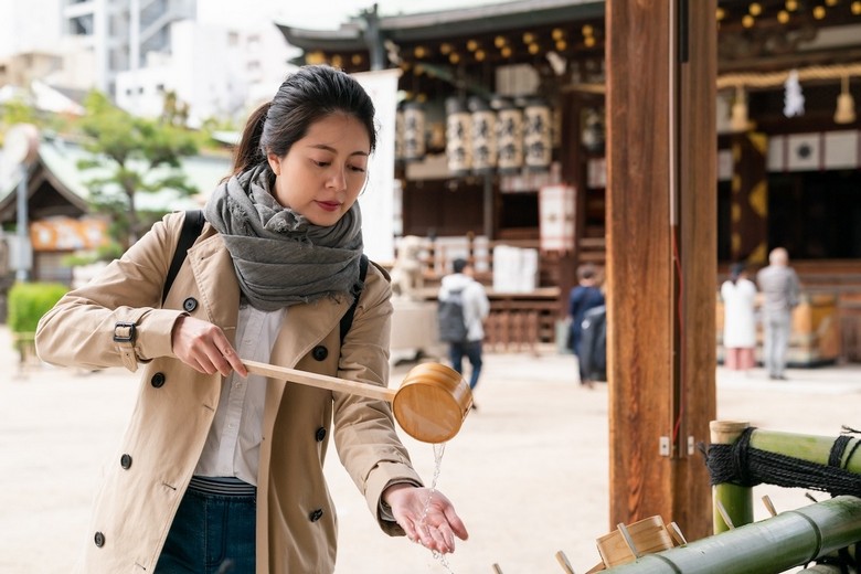 Cảnh khách du lịch múc nước tại temizuya trước khi vào đền thần Nhật Bản