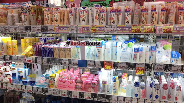 Bên trong cửa hàng Don Quijote với các kệ bánh kẹo, mỹ phẩm chật kín, biển hiệu màu vàng đặc trưng