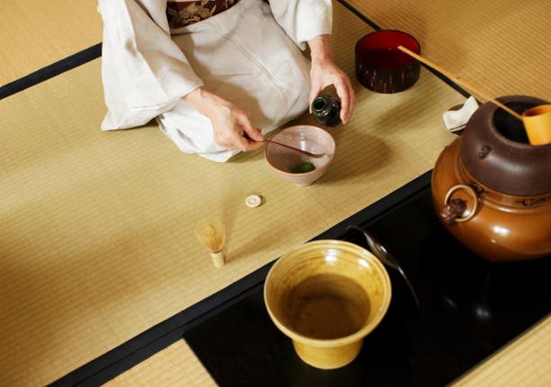 Một buổi trà đạo trong trà thất gỗ ở Kyoto với chủ trà đang đánh matcha