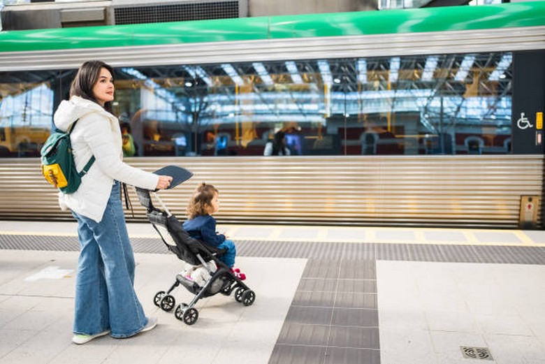 Bố mẹ đẩy xe em bé đi qua một ga tàu sạch sẽ ở Tokyo