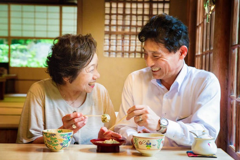 Người lớn tuổi nếm thử miếng wagashi nhỏ cùng tách trà