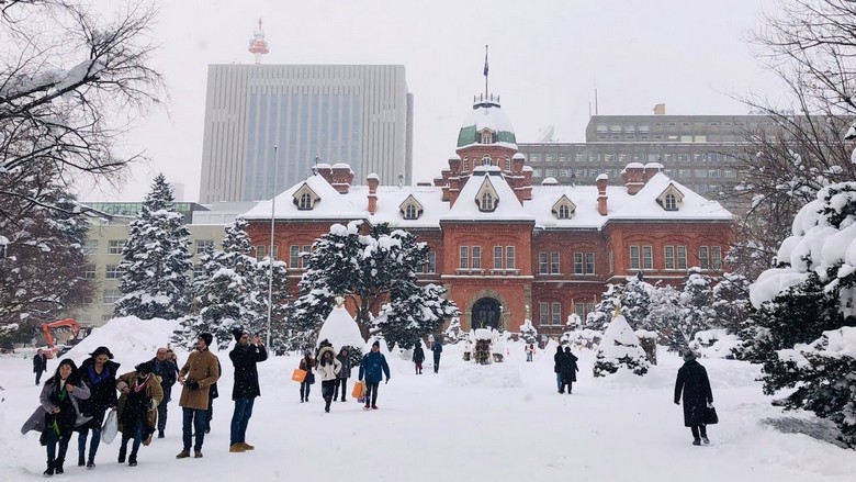  Du khách mặc áo khoác dày đi giữa tuyết trên phố Sapporo