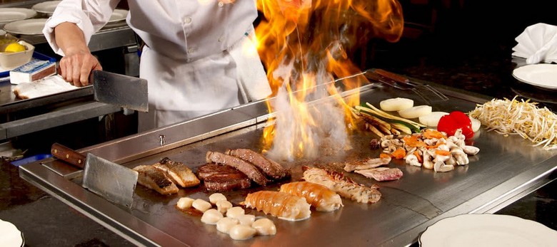 Đầu bếp nướng bò Kobe trên bàn teppanyaki trước mặt khách
